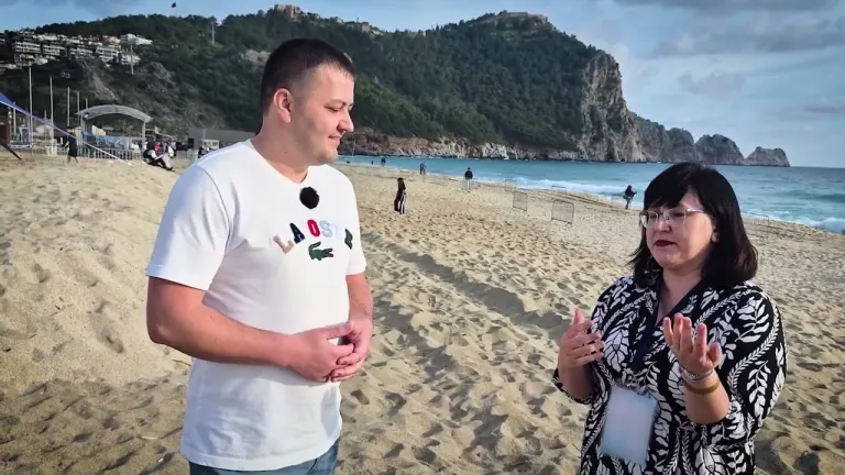 Наталья беседует с интервьюером на пляже — кадр из видео-кейса